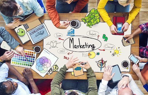 The word ‘marketing’ circled in red surrounded by related animations and people around a table The word ‘marketing’ circled in red surrounded by related animations and people around a table.